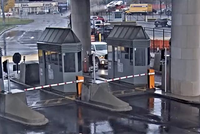 <p>Security video, a light colored vehicle, top center, flies over a fence into the Rainbow Bridge customs plaza</p>