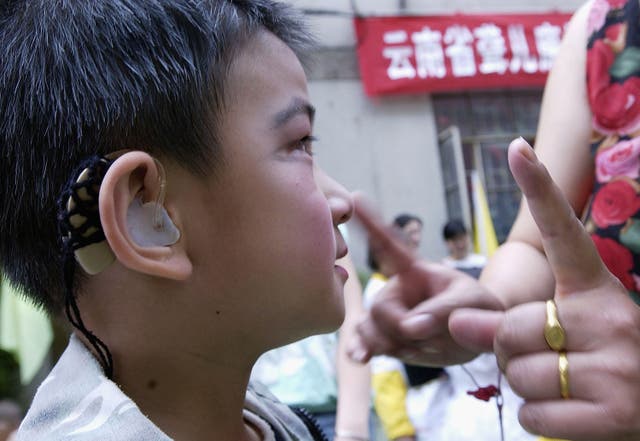 <p>A deaf child takes instructions before a performance to celebrate International Children’s Day at a rehabilitation centre for deaf children June 1, 2005 in Kunming, Yunnan Province, China</p>